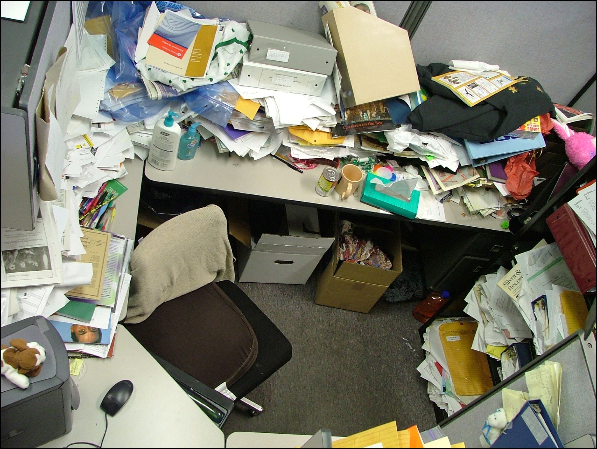 После длительного отсутствия. Стол заваленный бумагами. Беспорядок на рабочем месте. Беспорядок в кабинете. Грязное рабочее место в офисе.